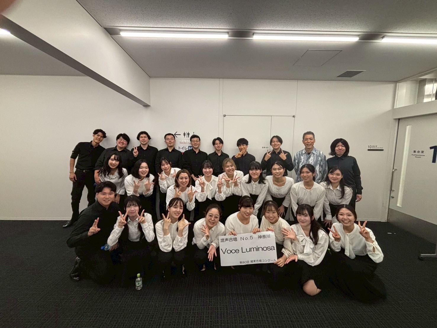 楽譜を見ながら並んで歌う二人の団員
